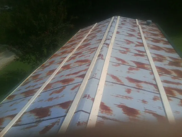 Rusted metal roof panels with new wood purlins before replacement — Storm Damage Roof Repair in Cogan Station by Roofing Brothers